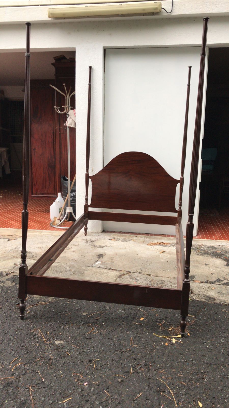 Carcasse de lit à colonnes sur un sol nu