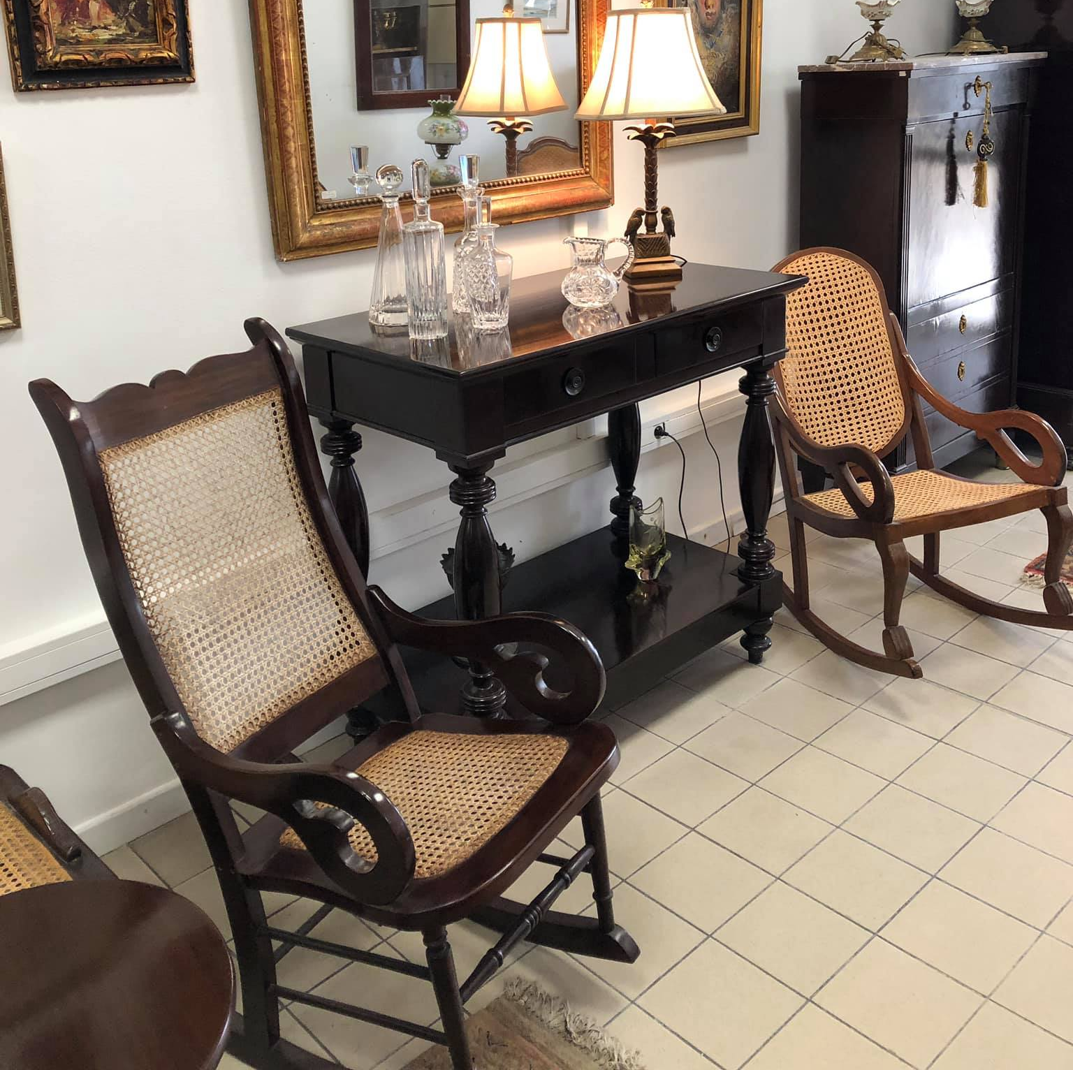 Deux sièges sombres à l'assise claire autour d'une table avec des verres dessus