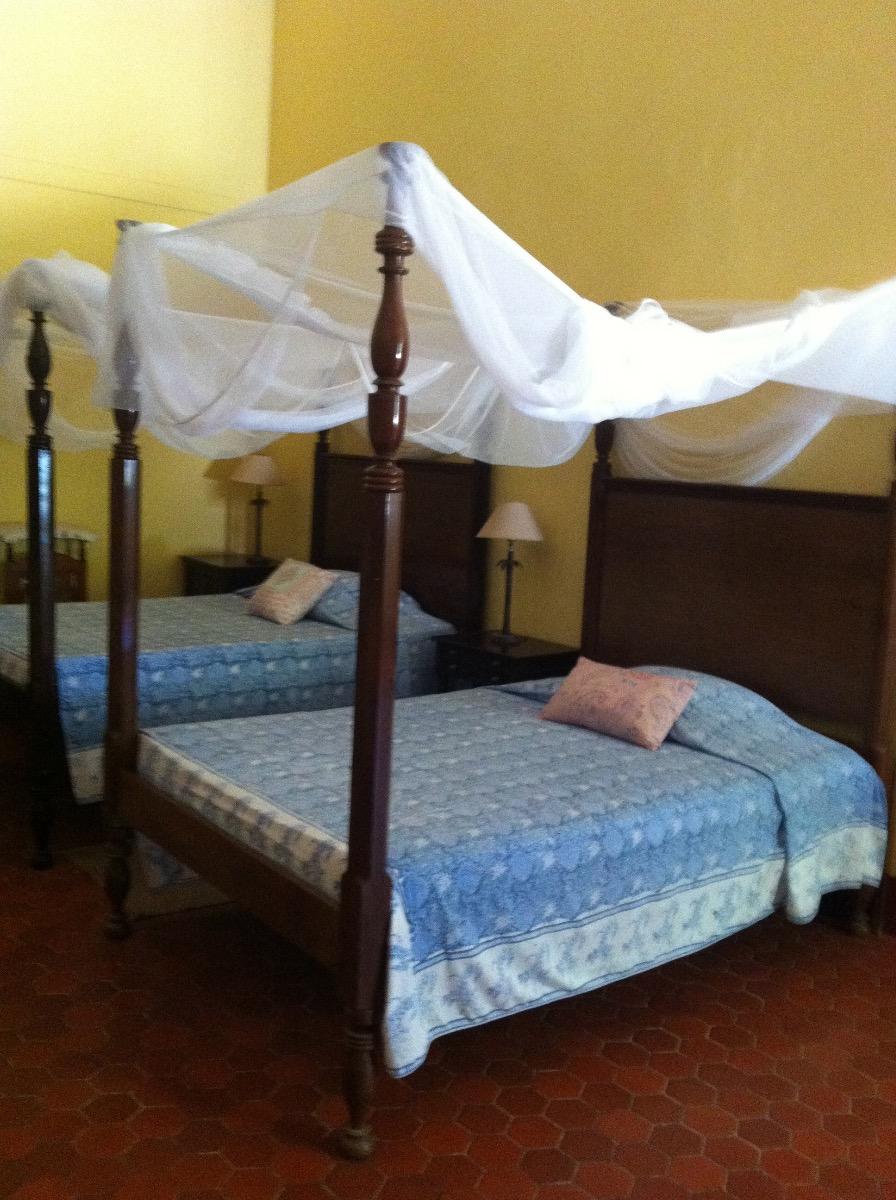 Doubles lits à baldaquin avec draps bleus et oreillers roses