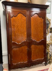Armoire vernie et ornementée avec un miroir derrière