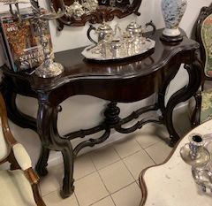 Console de couleur sombre aux pieds courbes avec de l'argenterie au-dessus