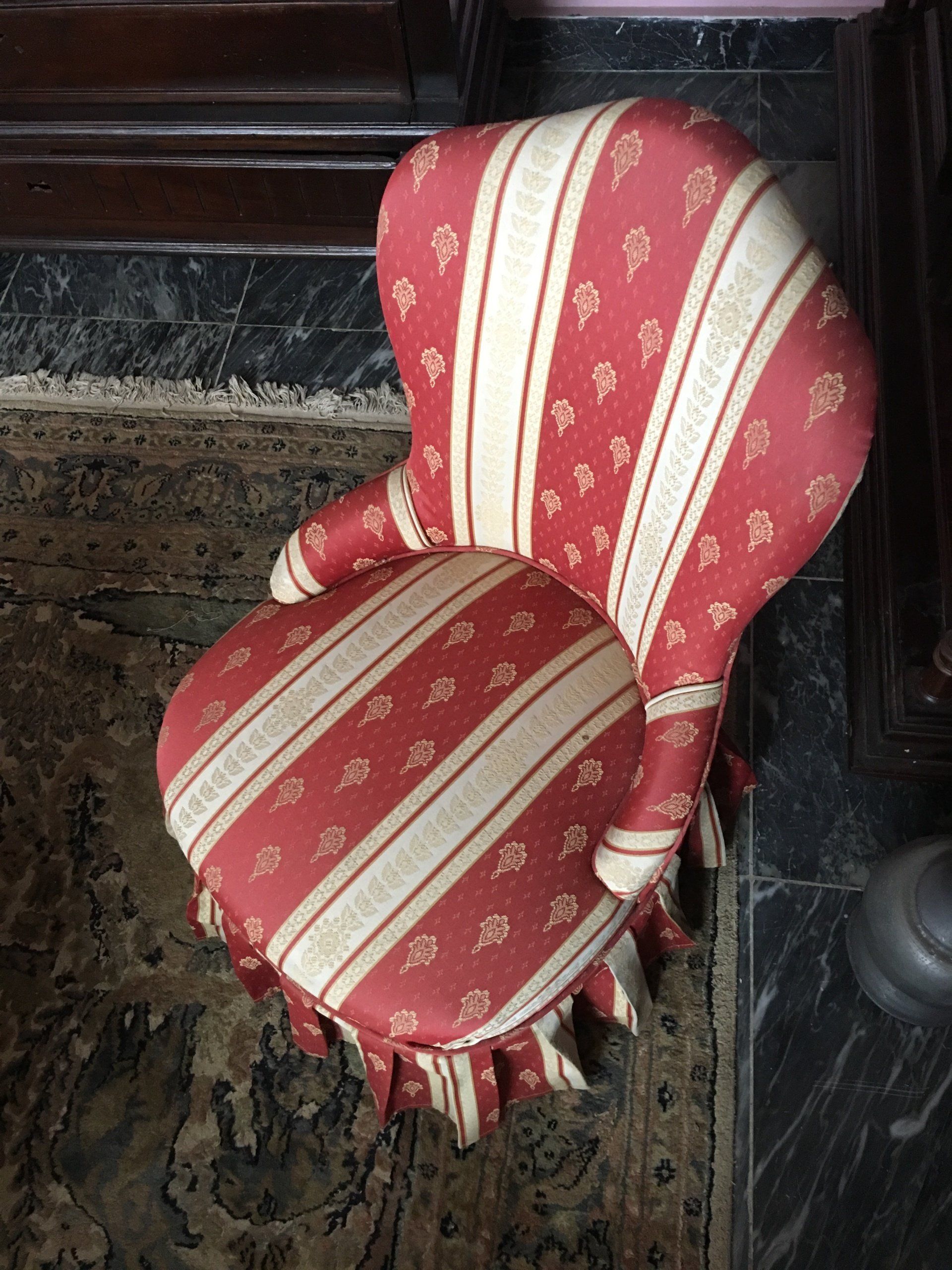 Petit siège sans bois apparent à la tapisserie rouge et blanche rayée et à motifs