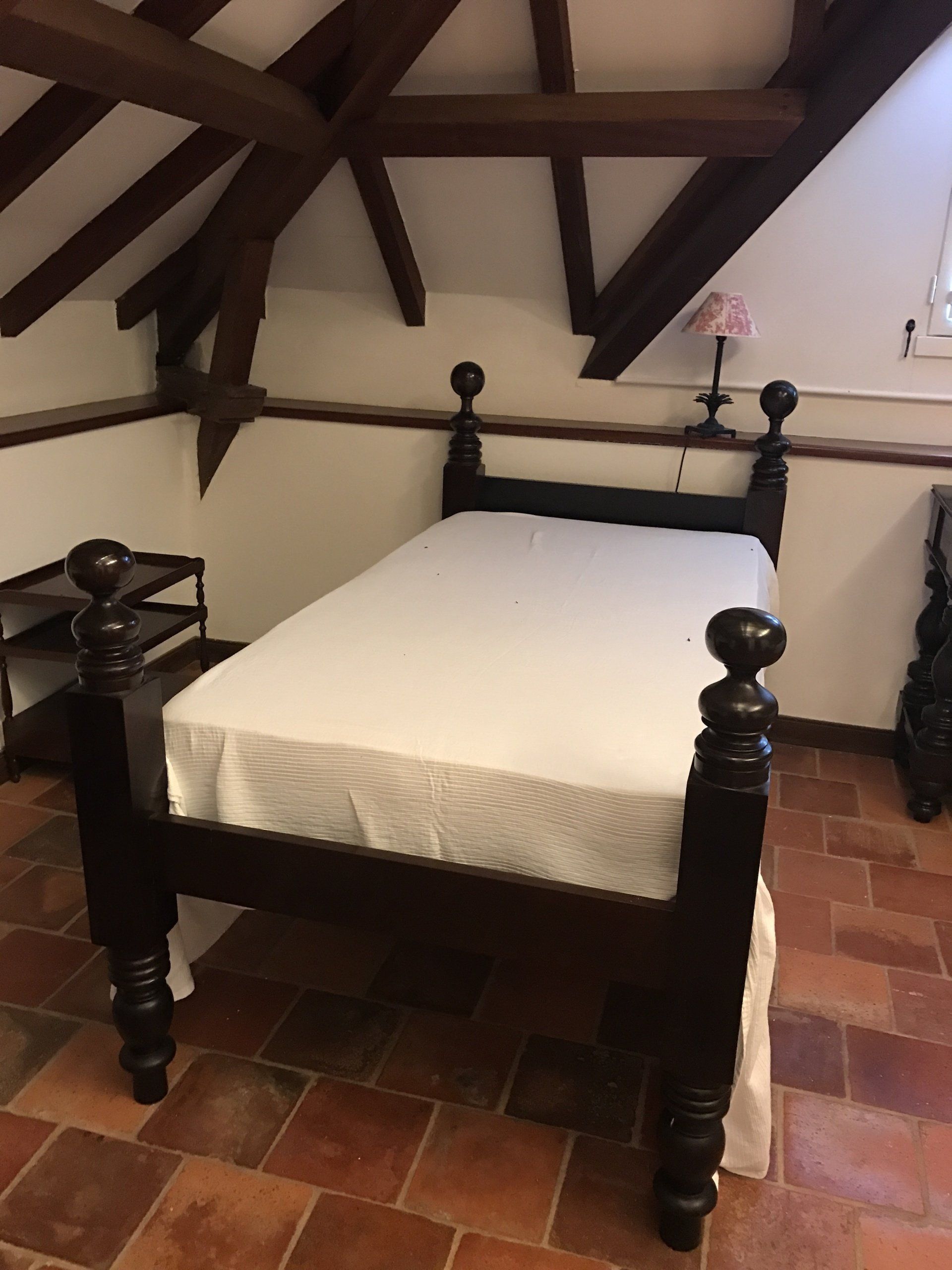 Lit à colonnes simple avec drap blanc