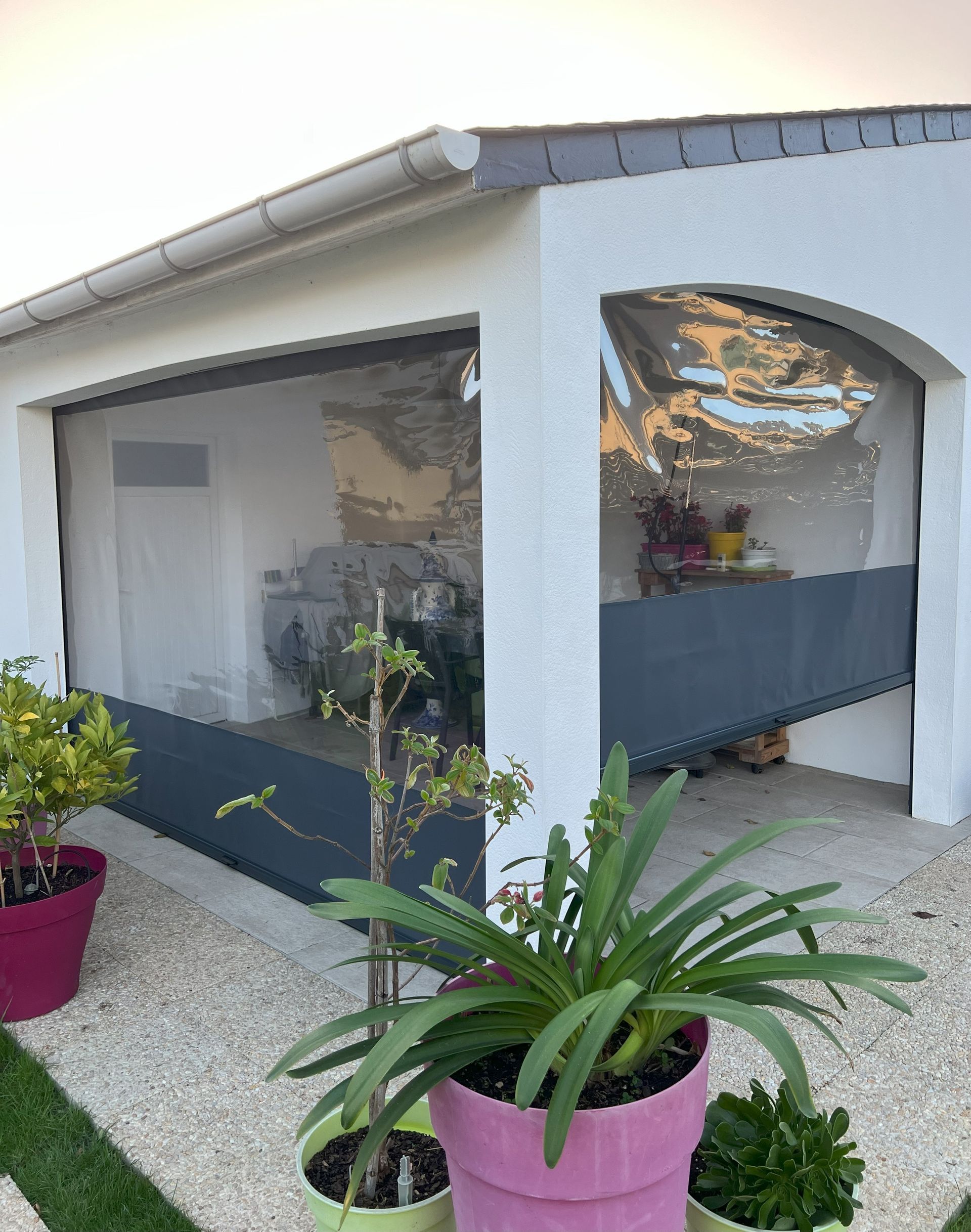 Aménagement d'un patio avec des stores ziptrak avec toile PVC en partie basse et ses fenêtres cristales