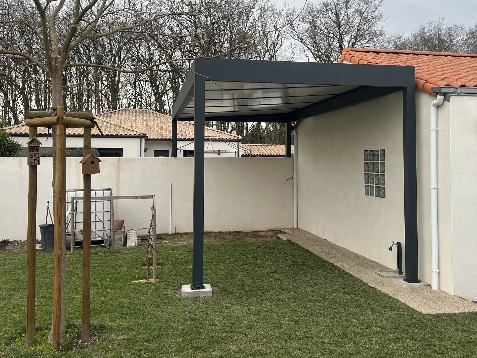 carport en aluminium avec 2 pieds posés sur muret et 2 pieds au sol