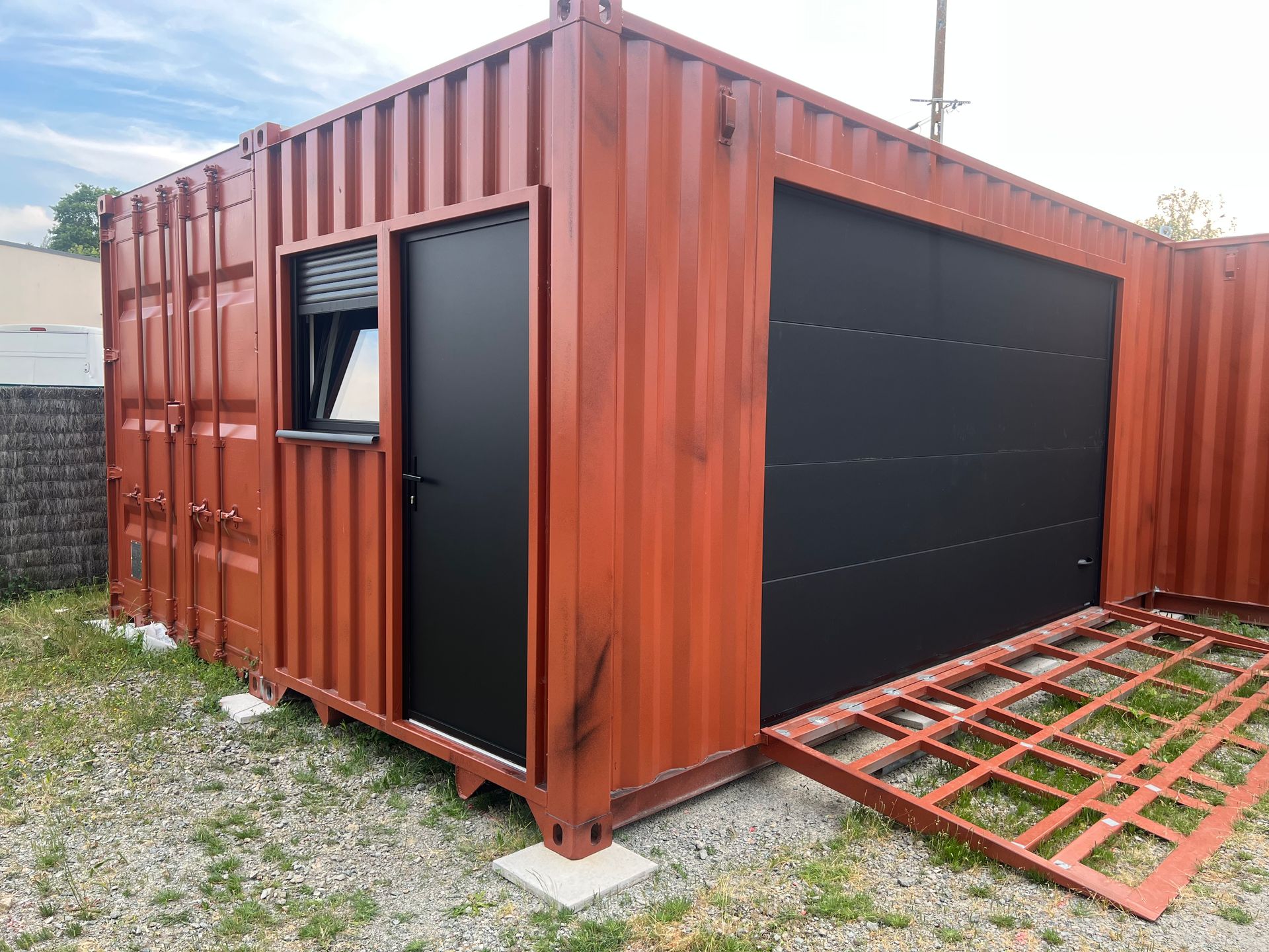 Porte de service aluminium, fenêtre et volet roulant aluminium, porte de garage sectionnelle plafond, le tout installé sur un conteneur
