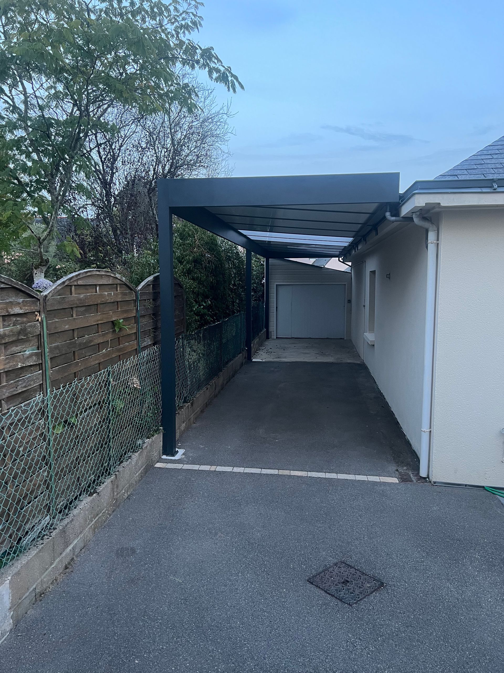 Carport aluminium de 12 ml de long adossé à la maison, toiture avec panneaux aluminium et panneaux plexiglass opale