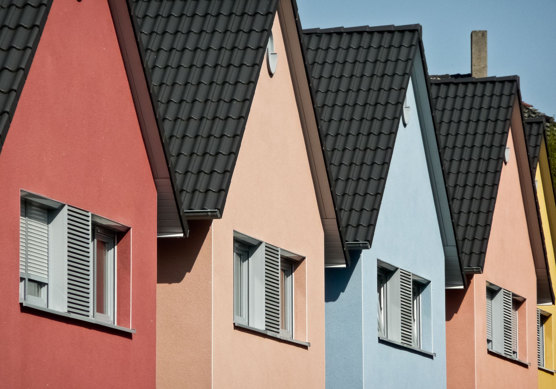 Eine Reihe bunter Häuser mit schwarzen Dächern