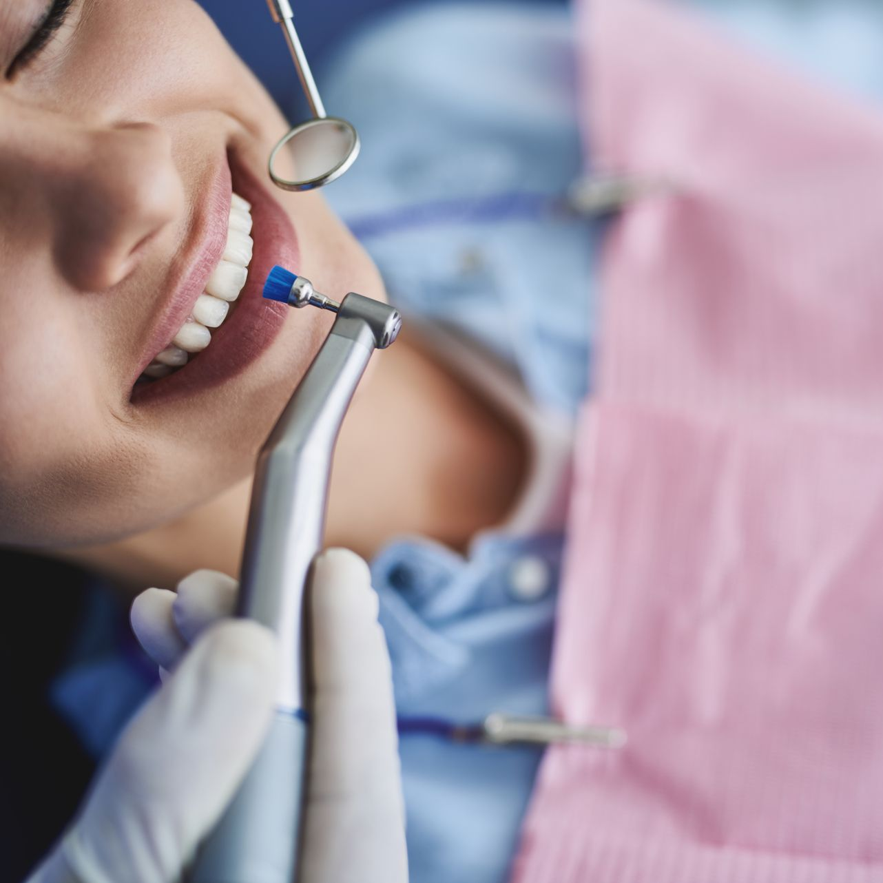 Femme recevant un traitement dentaire, souriante.