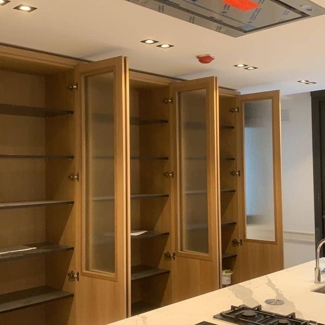 Una cocina con gabinetes de madera y puertas de vidrio.