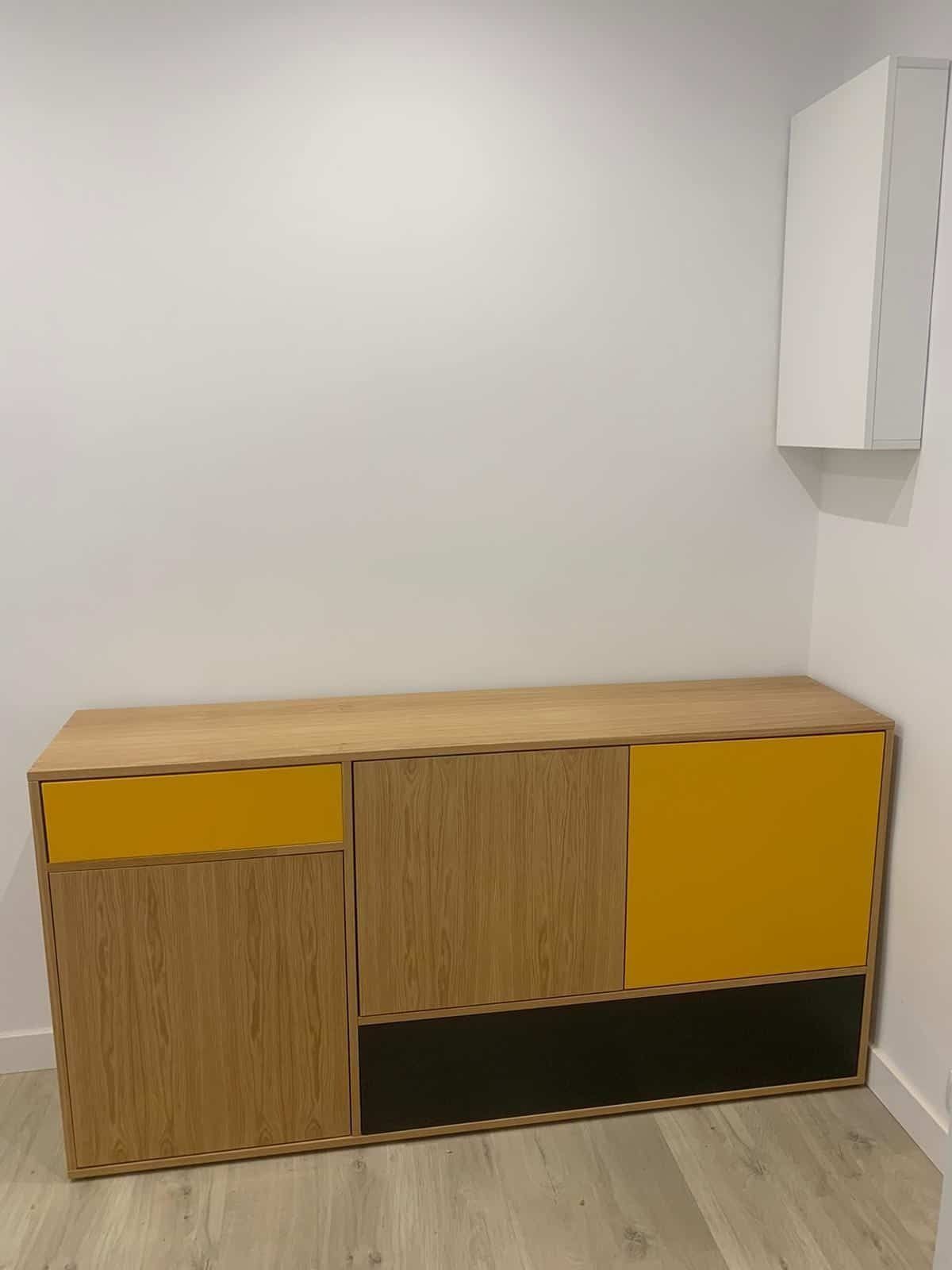 Un armario de madera con puertas y cajones amarillos en una habitación.