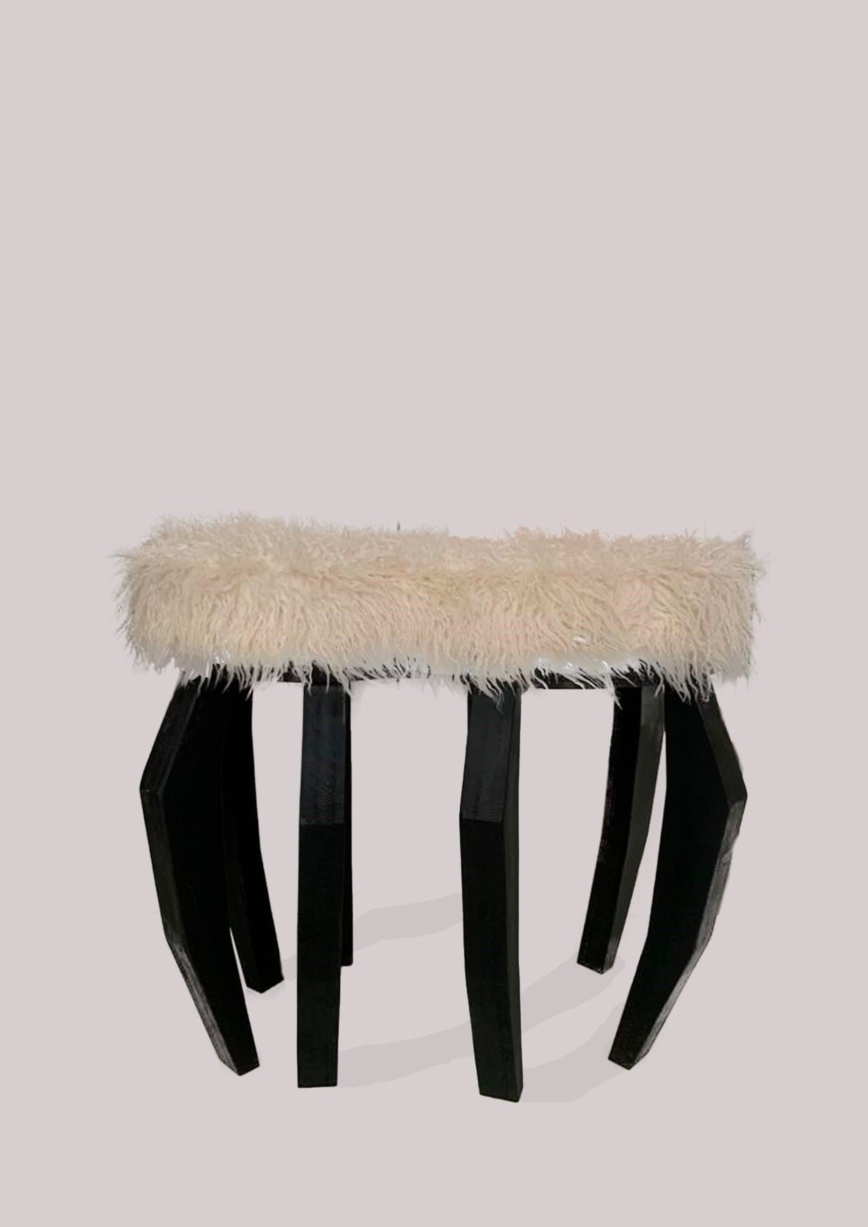 Un taburete con tapa peluda y patas negras sobre fondo blanco.