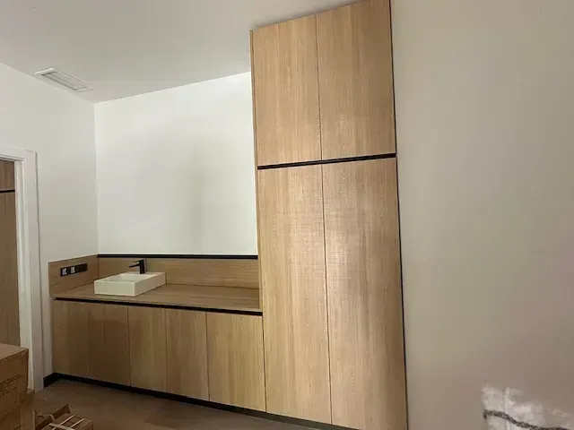 Un baño con muebles de madera y lavabo.