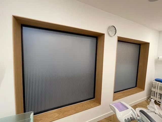 Un consultorio dental con dos ventanas y un reloj en la pared.