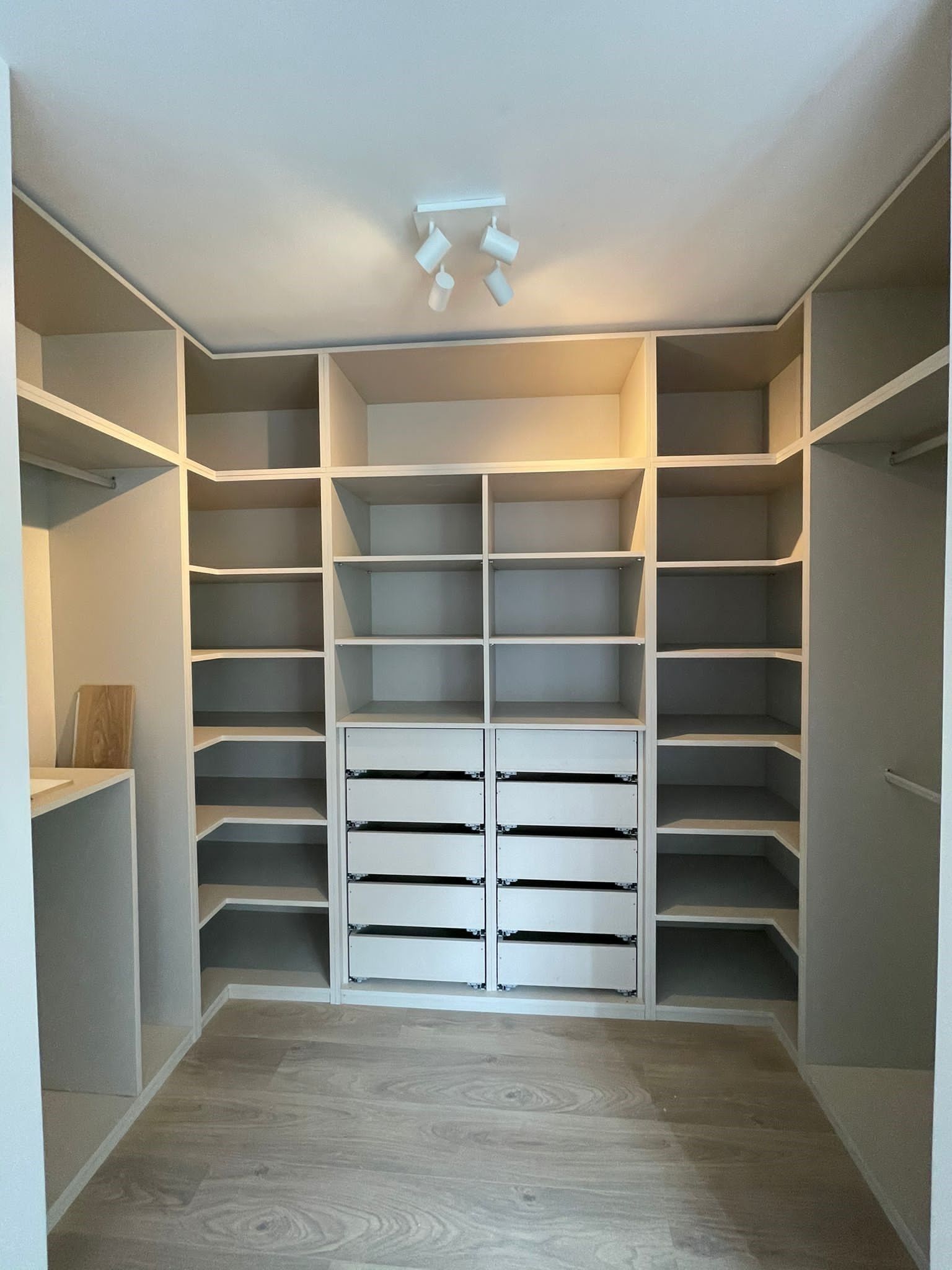 Un vestidor con muchos estantes y cajones.