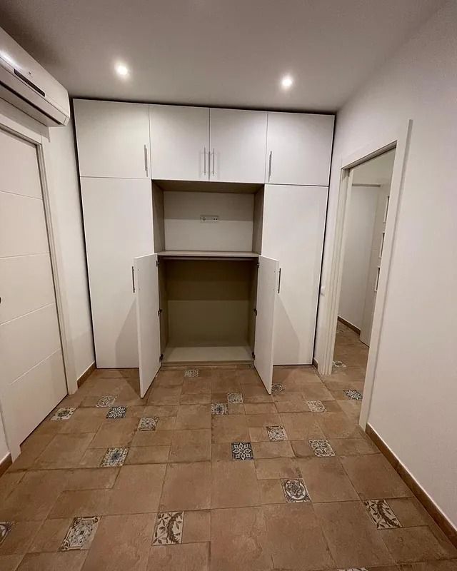 Hay un armario en el medio de la habitación con las puertas abiertas.