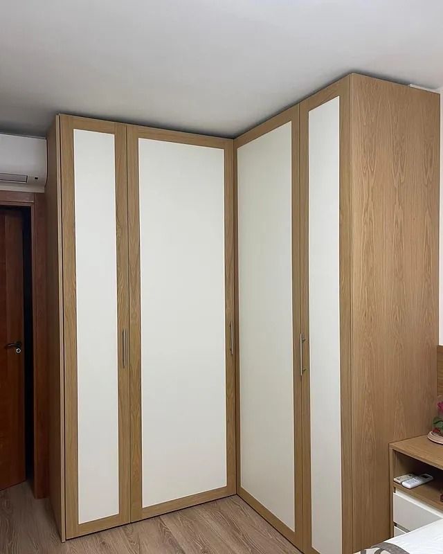 Un dormitorio con un armario esquinero y una cama.