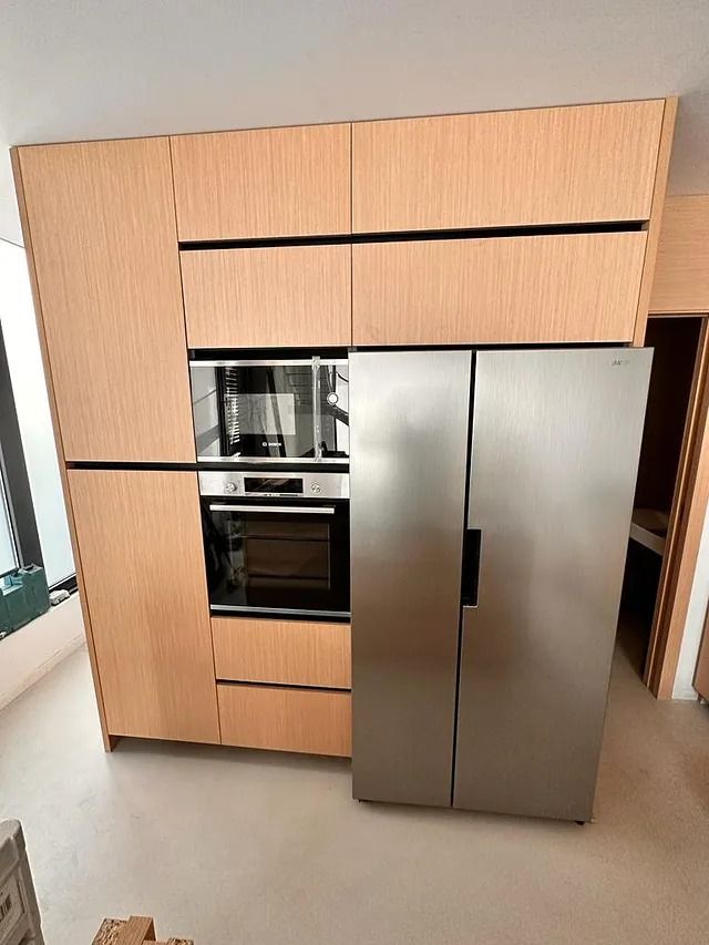 Una cocina con electrodomésticos de acero inoxidable y gabinetes de madera.