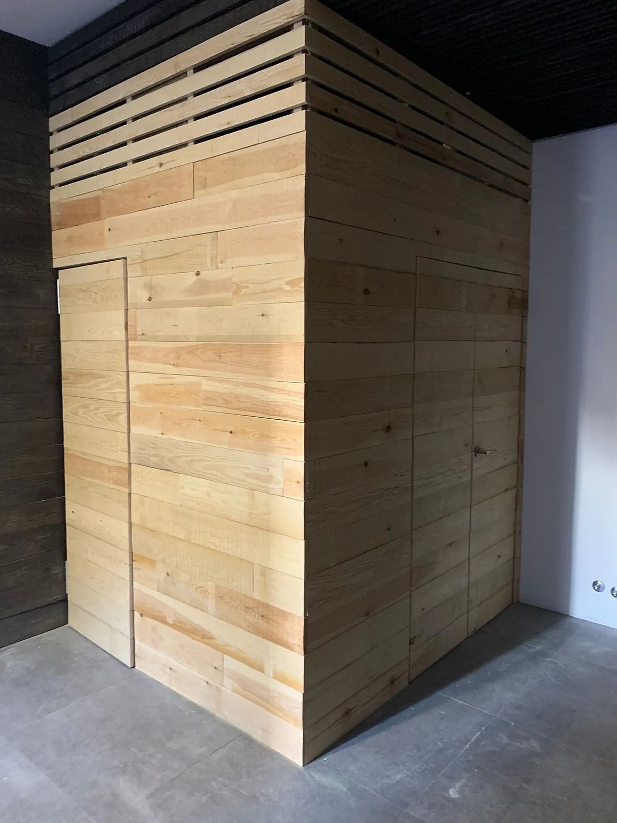 Una habitación con una pared de madera y una puerta