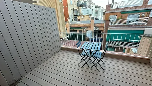 Un balcón con mesa y sillas y vista a una ciudad.