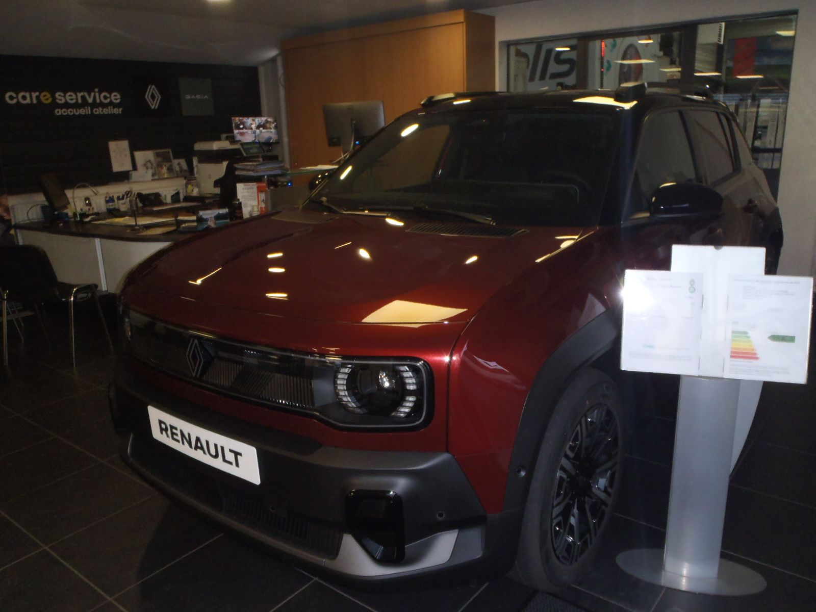 Un SUV Renault rouge exposé dans le showroom d'un concessionnaire.
