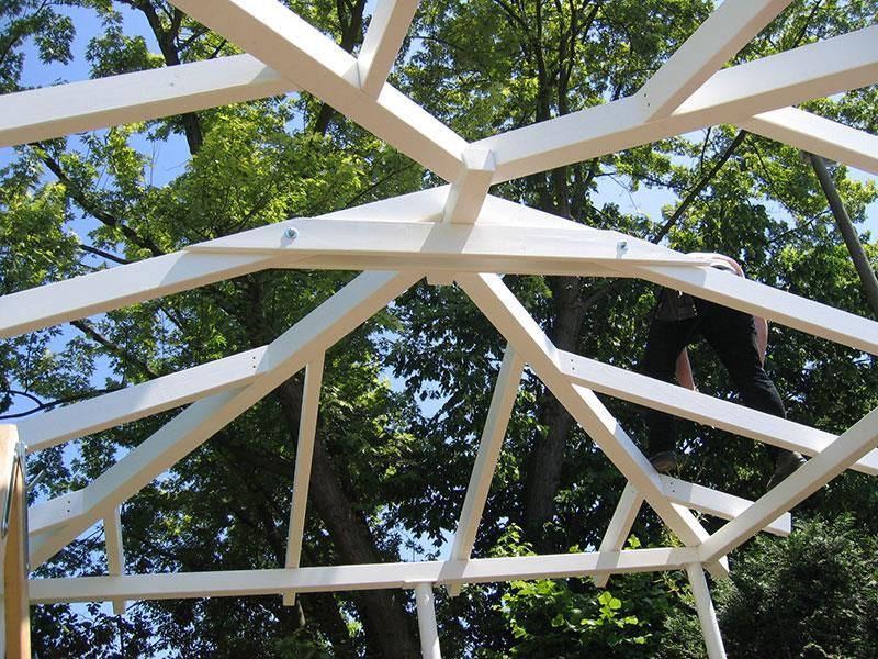 Ein weißes Gebäude mit Bäumen im Hintergrund wird gebaut