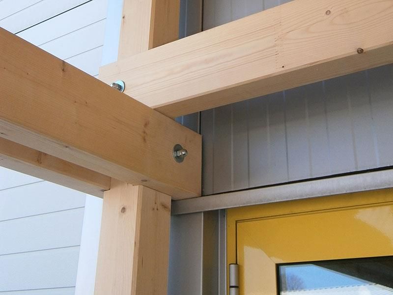 Eine Holzkonstruktion mit einer gelben Tür im Hintergrund