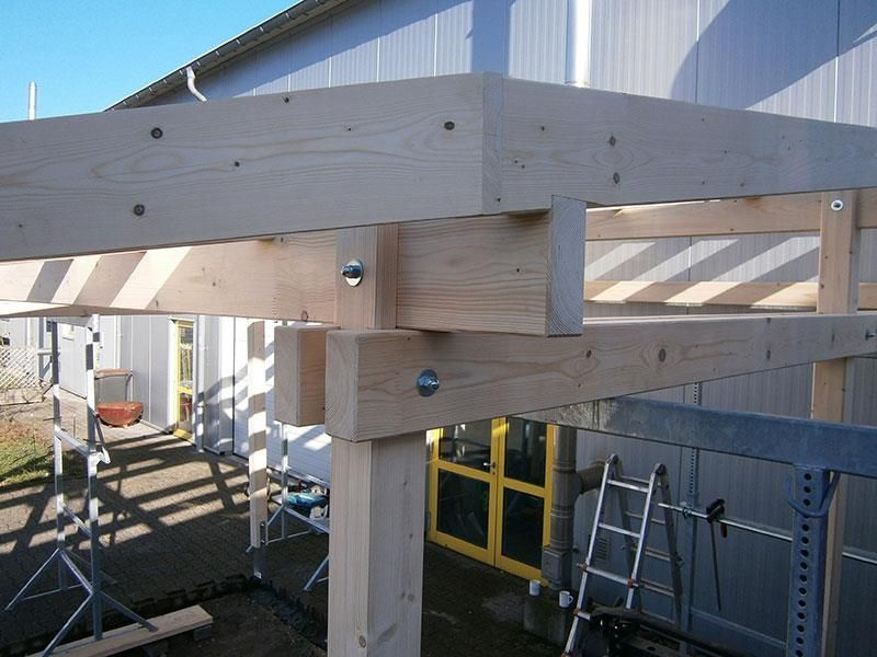 Vor einem Gebäude wird eine Holzkonstruktion errichtet