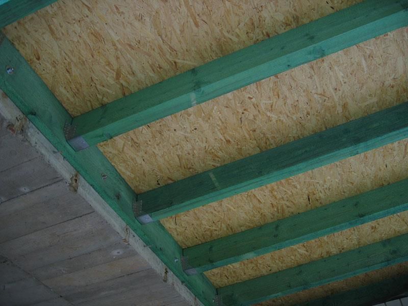 Eine Nahaufnahme einer Holzdecke mit grünen Balken.