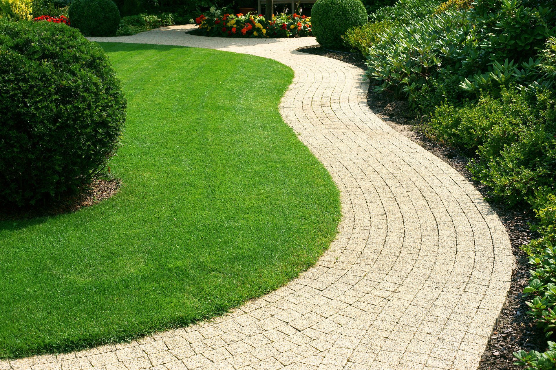 Un chemin en pavé entouré de pelouse