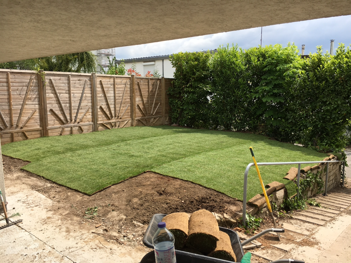 Jardin en cours d'engazonnement par rouleaux de pelouse