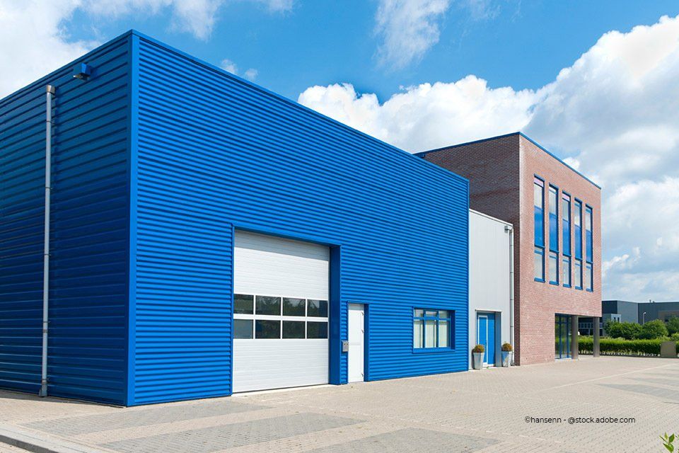 Weißes Tor in blauer Lagerhalle, installiert von IVS Industrietore & Verladetechnik GmbH & Co. KG