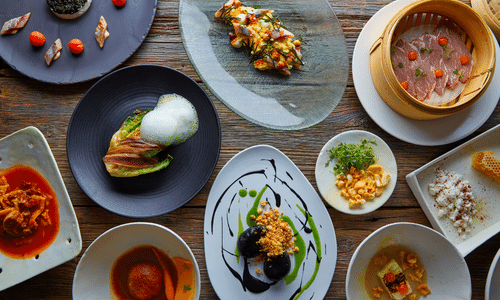 A table topped with plates and bowls of food.