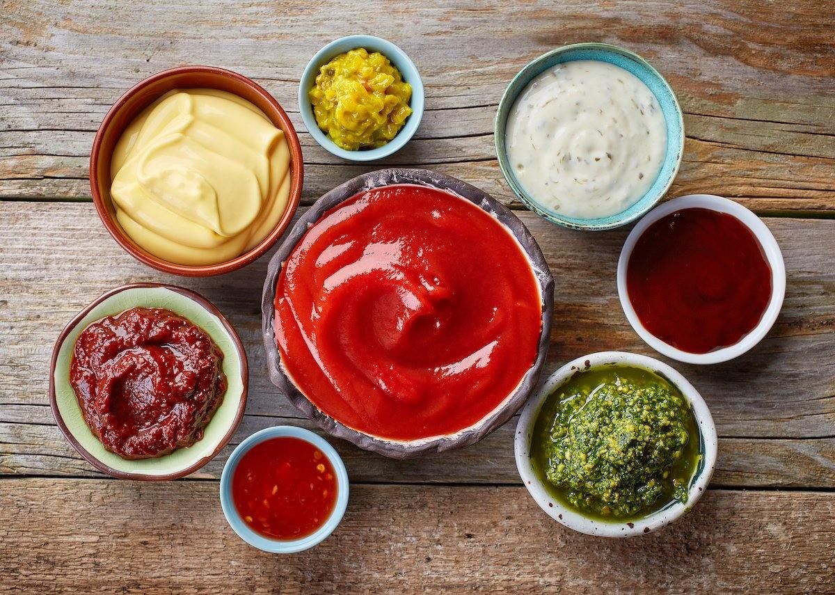 There are many different types of sauces in bowls on the table.