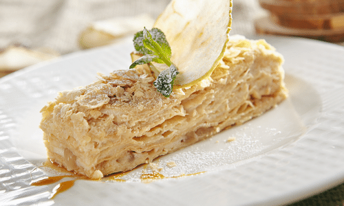 A piece of cake on a white plate with a fork.