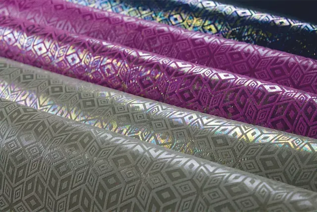 Un montón de telas de diferentes colores se apilan una encima de otra.