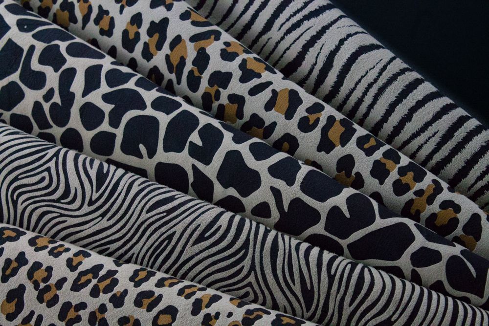 Un montón de telas con estampados de cebra y leopardo se apilan una encima de otra.