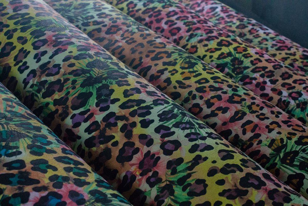 Un montón de rollos de tela con estampado de leopardo se apilan uno encima del otro.