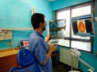Un dentista está mirando una radiografía en un consultorio dental.