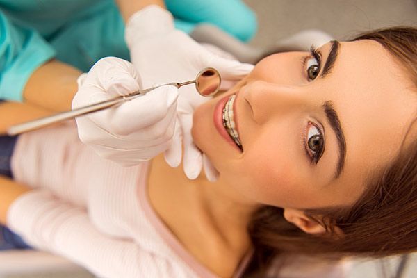 Una mujer está siendo examinada por un dentista.