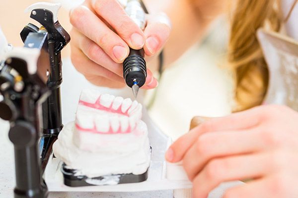 Un dentista está trabajando en un modelo de los dientes de una persona.