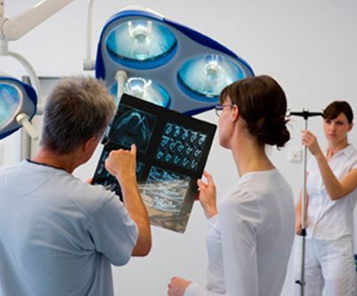 Un grupo de médicos está mirando una radiografía en un quirófano.