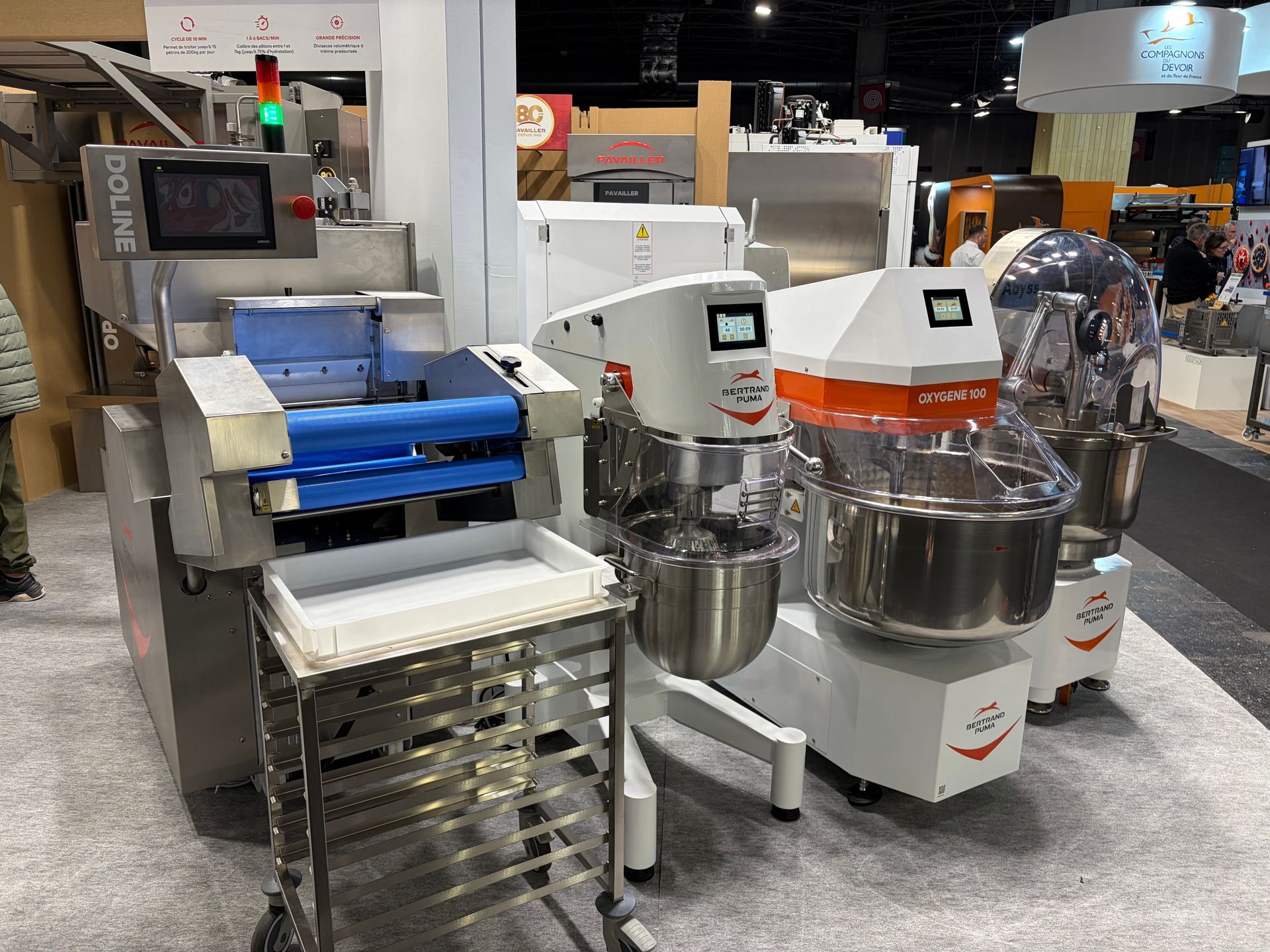 Matériel de boulangerie présenté au salon professionnel : pétrin et trancheuse à pain en acier inoxydable.