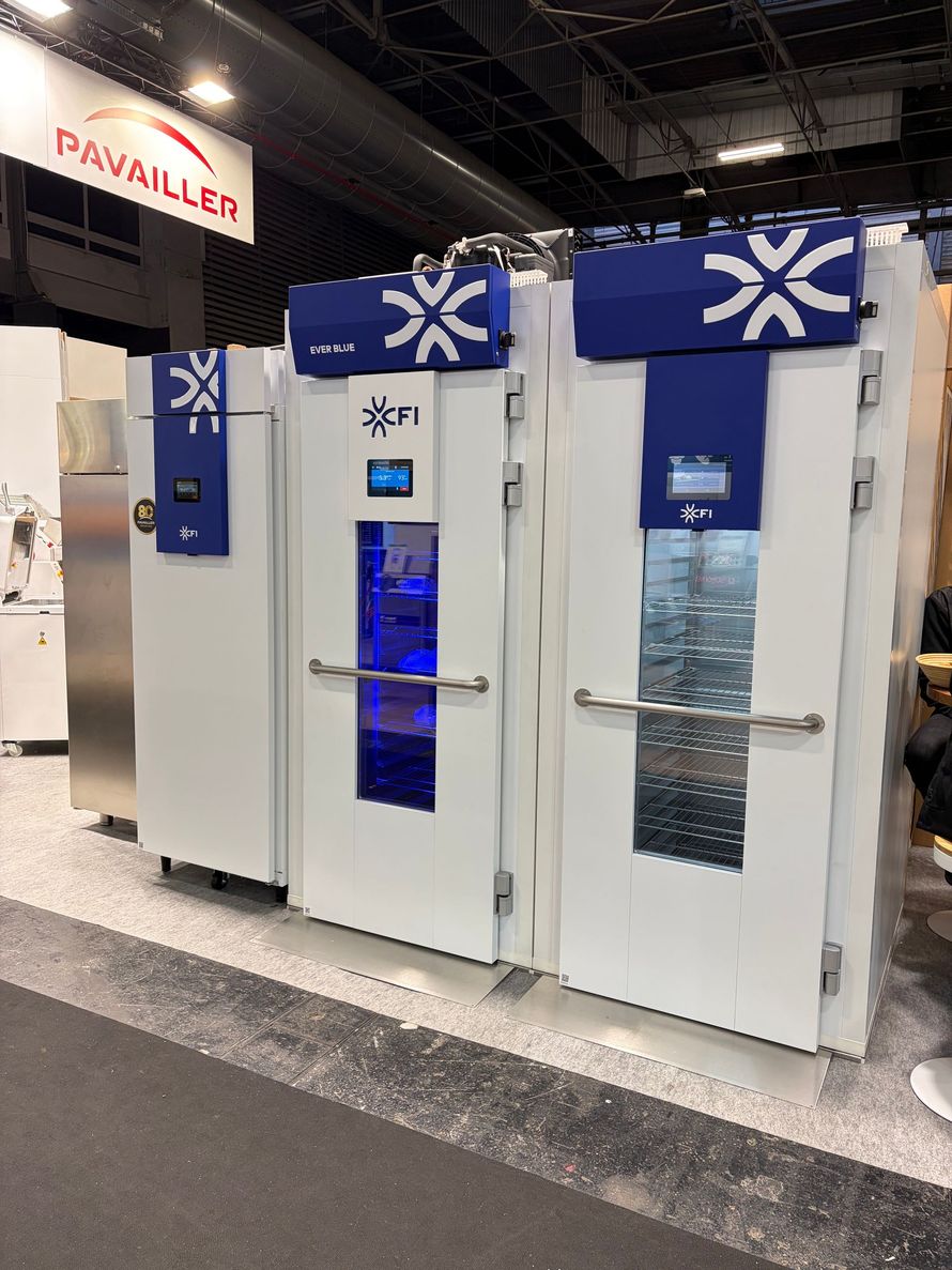 Unités de réfrigération industrielle blanches et bleues, portant l'inscription FI et dotées d'écrans lumineux, dans un contexte de salon professionnel.