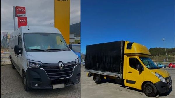 Dos furgonetas Renault, una blanca y otra amarilla, estacionadas frente a un concesionario de automóviles.