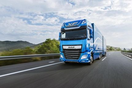 Un camión azul circula por una autopista.