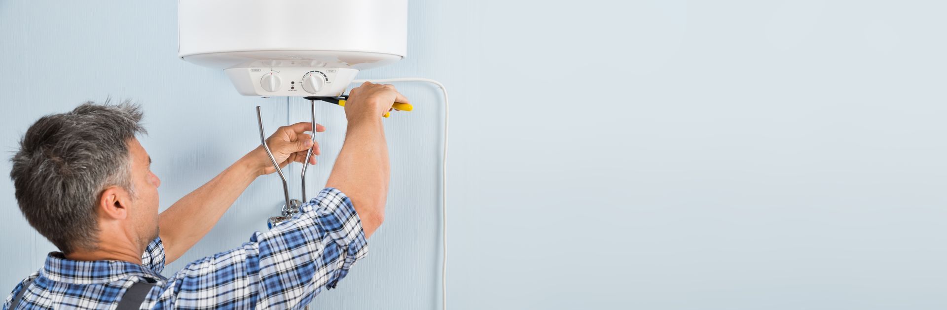 Un homme installe un chauffe-eau