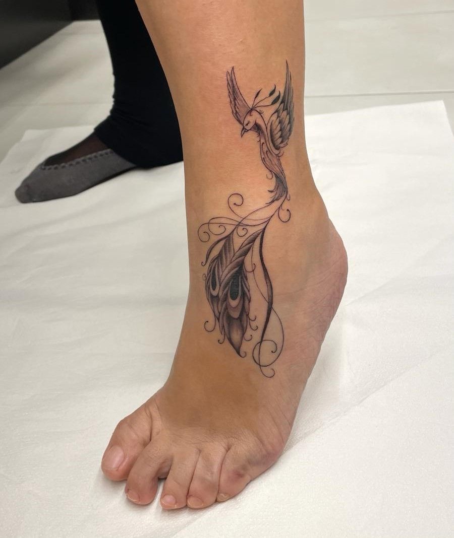 Una mujer tiene un tatuaje de un pájaro en el tobillo.