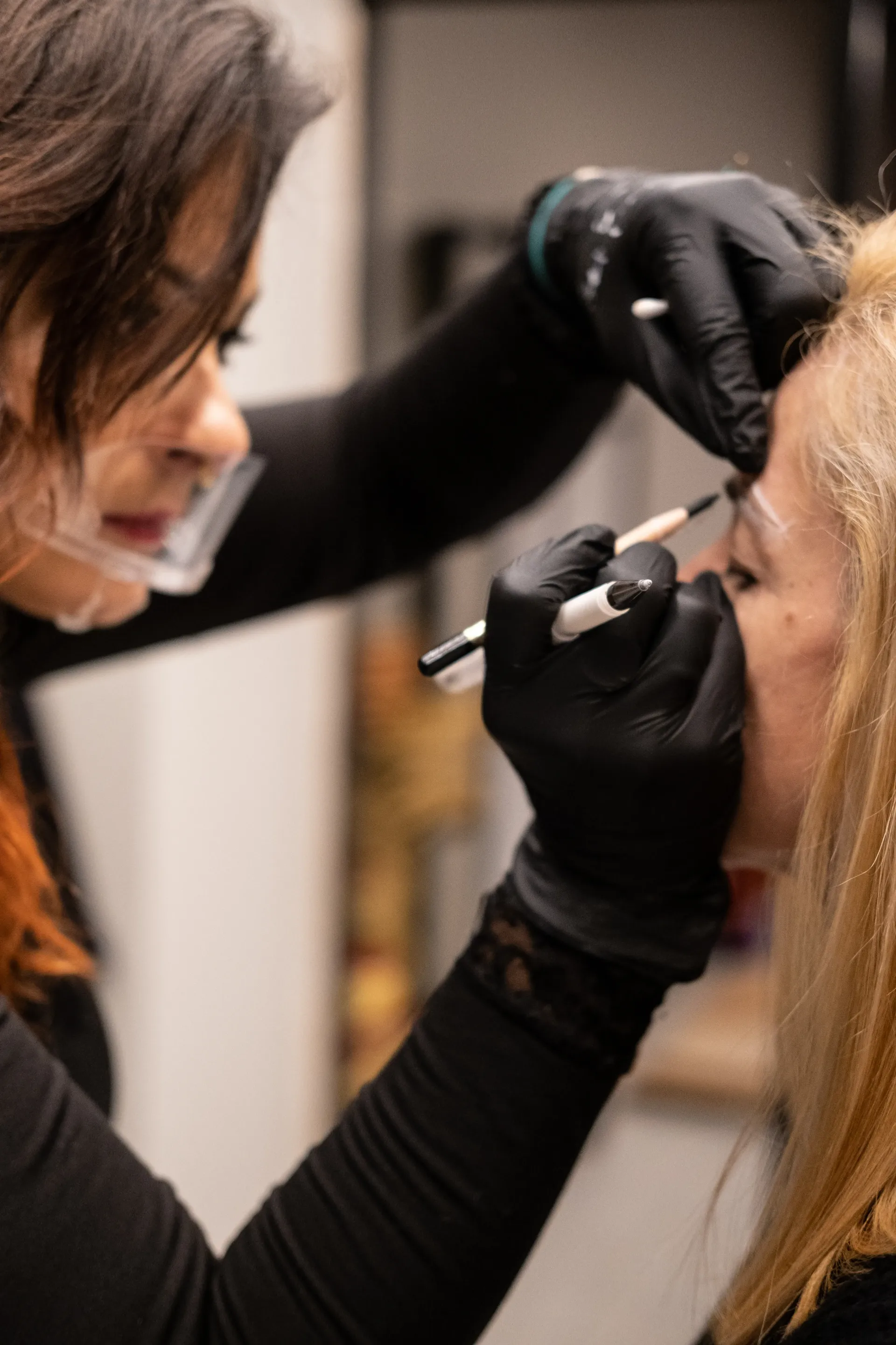 Una mujer se está haciendo un maquillaje para las cejas.