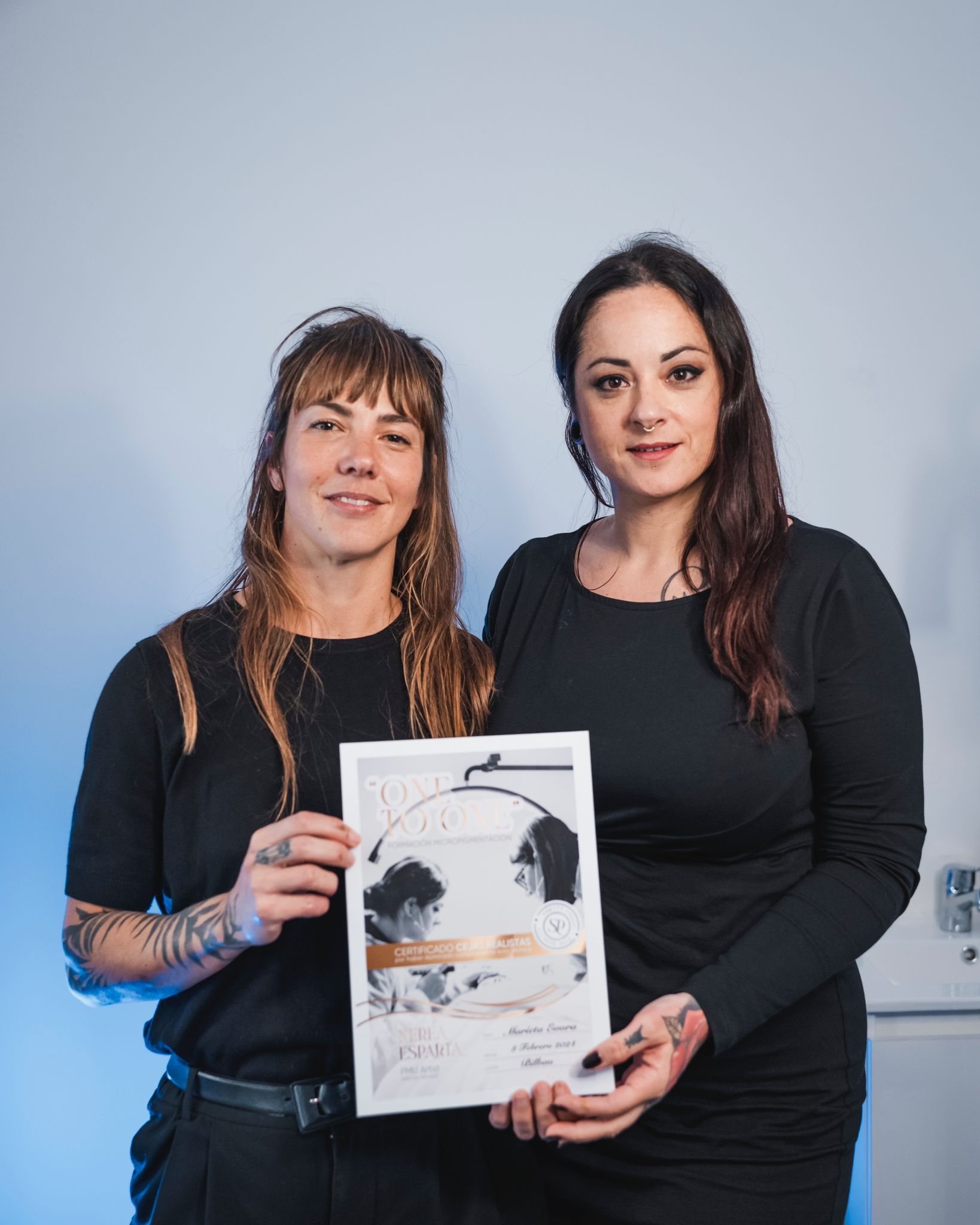 Dos mujeres están paradas una al lado de la otra sosteniendo un certificado.